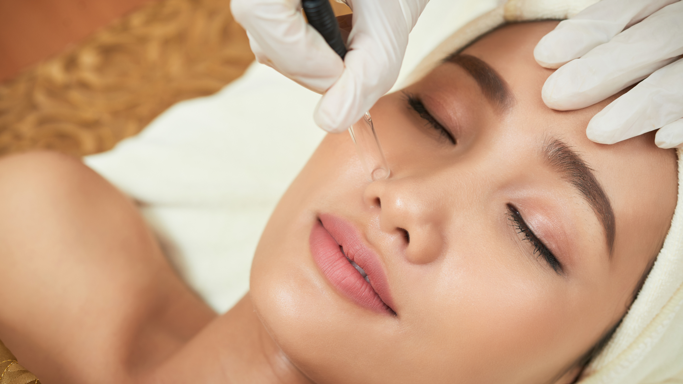 Esthetician performing a precision brow treatment as part of a fall beauty reset